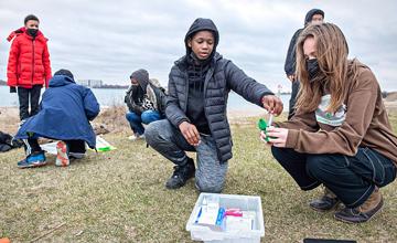 图为一群学生在底特律贝尔岛练习水质测试.